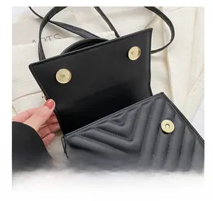 Gros plan des boucles magnétiques dorées sur un sac à main noir en cuir PU matelassé