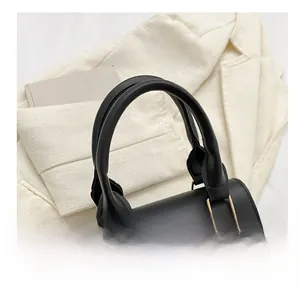 Vue détaillée du sac en cuir noir avec un grand logo V doré et une poignée ronde