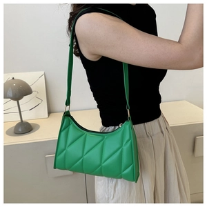 Detail of bright green quilted shoulder bag with rhombus stitching and PU leather texture