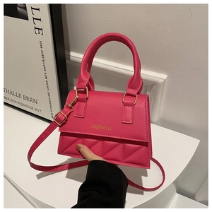 Detail of hot pink leather handbag with quilted flap and golden text from a side view