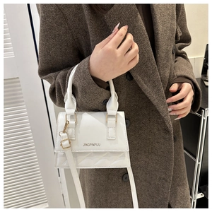 Detail of white quilted faux leather mini bag featuring gold hardware and logo