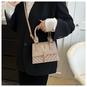 Dettaglio borsa a tracolla beige con logo a V dorato, nappa e cuciture trapuntate