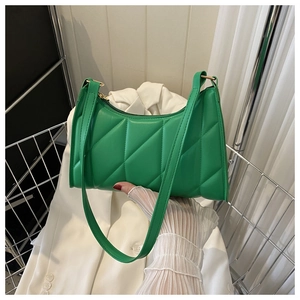 Detailed close-up of vibrant green quilted faux leather shoulder bag with chic metal zipper
