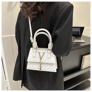 Vue détaillée du sac bandoulière blanc matelassé avec logo V doré et pompon sur modèle