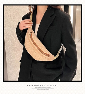 Detail of beige faux fur waist bag featuring golden zipper and adjustable canvas strap