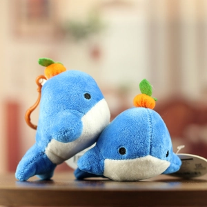 Detail of plush whale keychains with orange hooks and soft texture in blue and white
