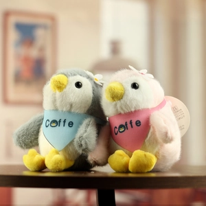 Detailed close-up of two plush penguin charms with soft fur and colorful coffee bibs