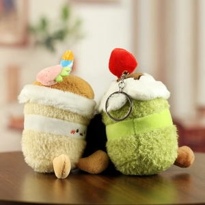 Détails de porte-clés cupcake en peluche avec fraise et bougie sur table