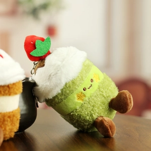 Macro d'un porte-clés gâteau à la fraise en peluche avec texture verte et crème blanche