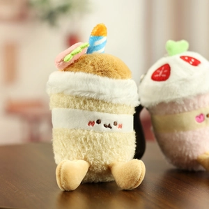 Gros plan d'un porte-clés cupcake en peluche avec bougie bleue et détail macaron