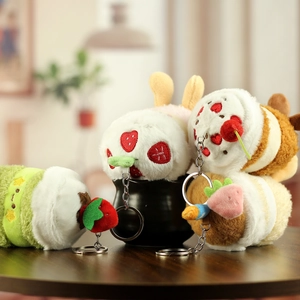 Lot de quatre breloques en peluche gâteau aux fruits avec porte-clés sur un bol décoratif