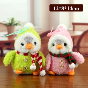 Porte-clés pingouins en peluche rose et vert avec écharpes sur table en bois