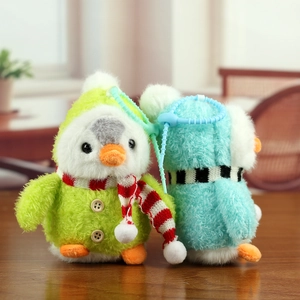 Détail de porte-clés pingouins en peluche avec écharpes rayées et texture douce
