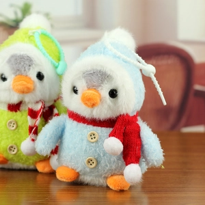 Gros plan de porte-clés pingouins en peluche bleue et verte avec écharpes tricotées