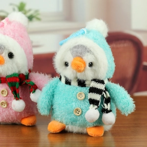 Gros plan de porte-clés pingouins en peluche rose et bleu avec tenues tricotées