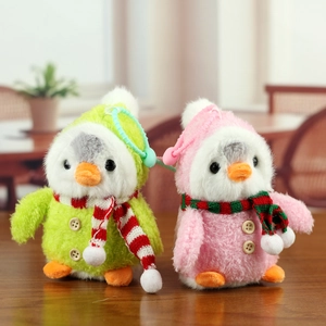 Détail de porte-clés pingouin en peluche avec écharpes colorées et bonnets rayés