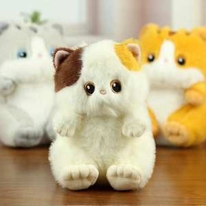 Detailed close-up of fluffy calico plush cat keychain with soft faux fur and embroidery