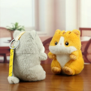 Close-up of plush cat keychains with soft faux fur and detailed embroidery on bags