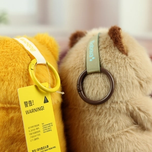 Detailed close-up of fluffy plush cat charms with safety tags and colorful hooks