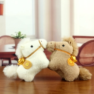 Close-up of plush horse keychains with gold ingots on a rustic wooden table
