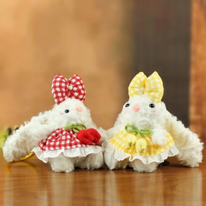 Détail de lapins en peluche avec robes à carreaux rouges et jaunes et nœuds