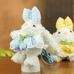 Détail d'un porte-clés lapin en peluche avec robe à carreaux bleus et dentelle