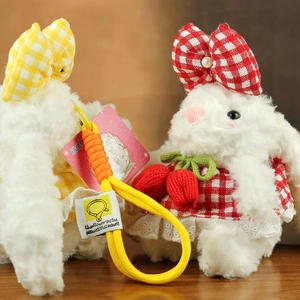 Gros plan de porte-clés lapin en peluche blanche avec robes en dentelle et cordons jaunes