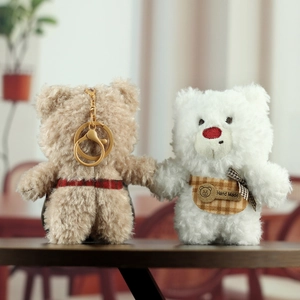 Detailed close-up of handmade plush teddy bear charms with soft fur and metal keychains