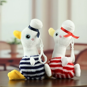 Dettaglio di portachiavi a forma di anatra marina in peluche a righe blu e rosse con clip