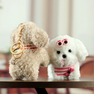 Detail of plush puppy keychains featuring a brown poodle and white dog with pink glasses