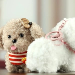 Close-up of cute plush puppy keychain with curly fur and striped scarf detail