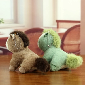 Gros plan de porte-clés chevaux en peluche doux marron et vert sur un bureau en bois