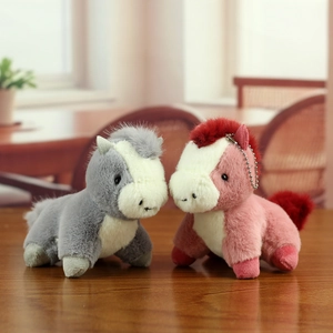 Gros plan de porte-clés cheval en peluche avec chaînes sur une surface en bois