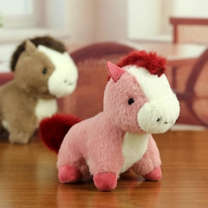 Détail d'un petit poney en peluche rose avec texture douce et crinière sur fond en bois