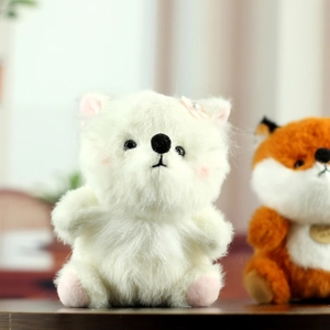 Gros plan d'une peluche renard blanc avec fourrure douce et nœud rose orné de perles