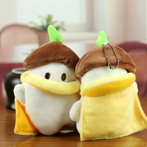 Close-up of cute long-tailed tit plush charms with acorn hats and yellow cloaks on wood
