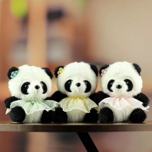 Tre panda di peluche con colletti di pizzo e fiori di perle su tavolo di legno