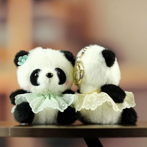 Portachiavi panda in peluche con colletti in pizzo e fiore verde menta in scena morbida
