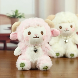 Close-up of plush sheep charms with pearls, heart pendants and clover embroidery detail