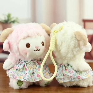 Close-up of cute plush sheep dolls in floral dresses with yellow braided keychains