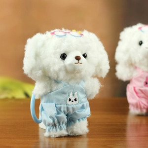 Détail d'un porte-clés chien en peluche blanche portant une salopette bleue et lunettes