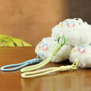 Détail de trois porte-clés chiens en peluche avec lunettes colorées et lanières tissées