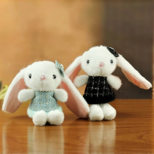 Paire de lapins en peluche aux grandes oreilles avec salopettes en tricot bleu et noir