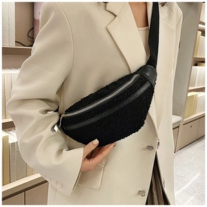 Close-up of black plush teddy fabric waist bag with silver zipper and leather trim