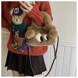 Détail du sac chiot en peluche marron avec de grands yeux et une bandoulière