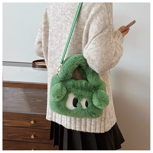 Détail du sac en peluche vert à grands yeux avec boucles métalliques dorées