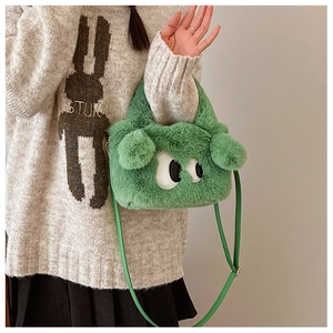 Détail du sac en peluche vert avec broderie gros yeux et bandoulière en similicuir