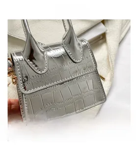 Detail of silver mini handbag showing glossy crocodile texture and metal chain strap