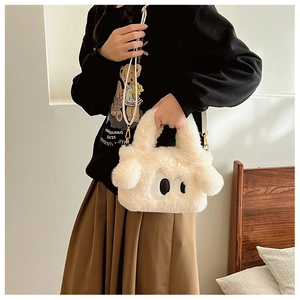 Détail du sac en peluche crème avec grands yeux, texture douce et boucle en métal doré