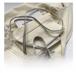 Detail of silver mini crossbody bag with crocodile pattern and metallic finish